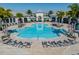 Aerial view showcases the community pool with ample lounge chairs and palm trees at 13822 Destin Beach Ln, Orlando, FL 32827