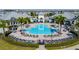 Aerial view showcasing the community pool with ample lounge chairs and palm trees at 13822 Destin Beach Ln, Orlando, FL 32827