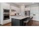 Kitchen with stainless steel appliances, white cabinets, island with gray stools and a large island at 13822 Destin Beach Ln, Orlando, FL 32827