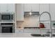 Modern kitchen featuring stainless steel appliances, white cabinets, and a center island sink at 13822 Destin Beach Ln, Orlando, FL 32827