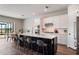 Modern kitchen featuring a large island with seating, white cabinets, and stainless steel appliances at 13822 Destin Beach Ln, Orlando, FL 32827
