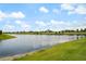 Scenic lake view showing the shoreline and lush green grass in a vibrant community at 13822 Destin Beach Ln, Orlando, FL 32827