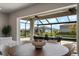 Outdoor screened patio offers a dining table, seating, and a fan, with a backyard view at 13822 Destin Beach Ln, Orlando, FL 32827