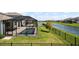 A screened-in pool and patio area overlook a scenic lake view in this backyard at 13822 Destin Beach Ln, Orlando, FL 32827