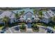 Pool entrance featuring a decorative archway, palm trees, landscaping, and lake views at 13822 Destin Beach Ln, Orlando, FL 32827