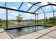 Picturesque view of the screened-in backyard pool and lake, creating a private oasis at 13822 Destin Beach Ln, Orlando, FL 32827