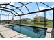 Enjoy the tranquil view of the screened-in backyard pool and serene lake views beyond at 13822 Destin Beach Ln, Orlando, FL 32827