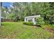 Landscaped backyard features a storage shed, mature trees, and privacy fence at 1576 Crosswind Cir, Orlando, FL 32825