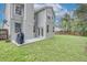Spacious backyard features a well-maintained lawn, patio, and modern gray exterior of the home at 1576 Crosswind Cir, Orlando, FL 32825