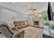 Spacious living room with a fireplace, ceiling fan, and comfortable leather seating at 1576 Crosswind Cir, Orlando, FL 32825