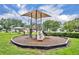 Outdoor playground equipment is surrounded by safety mulch, with a gazebo in the background at 1576 Crosswind Cir, Orlando, FL 32825
