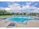 A bright blue community pool is surrounded by lounge chairs and manicured lawns at 1576 Crosswind Cir, Orlando, FL 32825