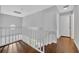 Upstairs landing with white railing and hardwood floors, leading to bedrooms and living spaces at 1576 Crosswind Cir, Orlando, FL 32825