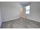 Bright bedroom with gray wood-look flooring, window with blinds, and access to the attached closet at 1727 Butterfly Way, Longwood, FL 32750