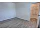 Bright bedroom with gray wood-look flooring and an open door to the attached closet with shelving at 1727 Butterfly Way, Longwood, FL 32750