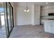 Bright dining area with sliding glass doors, modern light fixture, and gray wood-look tile floors at 1727 Butterfly Way, Longwood, FL 32750