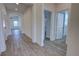 Hallway with wood-look tile flooring leads to several rooms with white walls and doors at 1727 Butterfly Way, Longwood, FL 32750