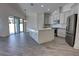 Well-lit kitchen showcasing an island, stainless steel appliances, and a seamless flow to the living space at 1727 Butterfly Way, Longwood, FL 32750