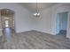 Bright and airy living area with wood-look tile floors and view into entryway at 1727 Butterfly Way, Longwood, FL 32750
