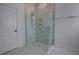 A modern glass enclosed shower stall with a rainfall showerhead and tiled walls with a built in storage shelf at 1727 Butterfly Way, Longwood, FL 32750