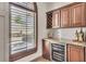 Custom bar area featuring wine storage, marble countertops, and natural light from the window at 1745 Seneca Blvd, Winter Springs, FL 32708