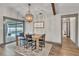 Bright dining room with pool view, stylish chandelier, and natural wood table at 1745 Seneca Blvd, Winter Springs, FL 32708