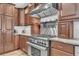 Gourmet kitchen with a stainless steel range, custom wood cabinetry, and modern vent hood at 1745 Seneca Blvd, Winter Springs, FL 32708