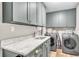 Functional laundry room offering modern appliances, sink, and overhead cabinet storage at 1745 Seneca Blvd, Winter Springs, FL 32708