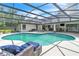 Beautiful screened-in pool and patio with lounge seating, a dining table, and outdoor kitchen at 1745 Seneca Blvd, Winter Springs, FL 32708