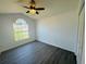 Bedroom featuring a large window, ceiling fan and gray floors, offering neighborhood views at 215 Hollowbrook Cir, Daytona Beach, FL 32114