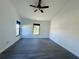 Bedroom with gray floors, large windows, and a ceiling fan, providing a comfortable and inviting space at 215 Hollowbrook Cir, Daytona Beach, FL 32114