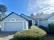 Well-maintained single-story home featuring an attached garage, manicured lawn, and front shrubs at 215 Hollowbrook Cir, Daytona Beach, FL 32114