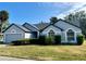 Charming single-story home with gray paint and dark trim, with a well-manicured lawn at 215 Hollowbrook Cir, Daytona Beach, FL 32114