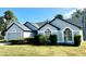 Well-maintained single-story home featuring an attached garage, manicured lawn, and lush shrubbery at 215 Hollowbrook Cir, Daytona Beach, FL 32114