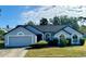 Charming single-story home featuring an attached garage, well-manicured lawn, and large arched windows at 215 Hollowbrook Cir, Daytona Beach, FL 32114