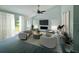 Staged living room with vaulted ceiling, fan, gray wood-look flooring, sliding glass door to yard, and fireplace at 215 Hollowbrook Cir, Daytona Beach, FL 32114
