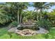 Lush backyard oasis with stone waterfall and tropical landscaping at 2325 Bella Luna Cir, Lakeland, FL 33810