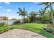 Well-maintained backyard featuring lush landscaping, mature palm trees, and a decorative paver patio at 2325 Bella Luna Cir, Lakeland, FL 33810