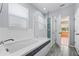 Bathroom showcasing a soaking tub, glass shower enclosure, and tiled walls, and flooring at 2325 Bella Luna Cir, Lakeland, FL 33810
