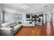 Open-concept living room featuring wood floors, a gray sectional sofa, and a kitchen in the background at 2325 Bella Luna Cir, Lakeland, FL 33810