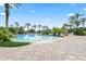 Large community swimming pool surrounded by lush landscaping and palm trees at 2325 Bella Luna Cir, Lakeland, FL 33810