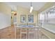 Bright dining room with white table, tile floors, and a window letting in natural light at 2627 Autumn Creek Cir, Kissimmee, FL 34747