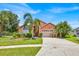 Charming single-Gathering home with a well-maintained lawn, palm trees, and an attached two-car garage at 2627 Autumn Creek Cir, Kissimmee, FL 34747