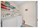 A well-organized laundry room with shelving above the modern washer and dryer at 2627 Autumn Creek Cir, Kissimmee, FL 34747