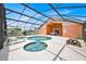 Screened-in pool with attached jacuzzi, dining table, and sun loungers at 2627 Autumn Creek Cir, Kissimmee, FL 34747