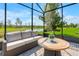 Screened lanai with a comfortable outdoor sofa, table, and beautiful view of the pond at 2793 Nature View Rd, St Cloud, FL 34771