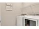 Laundry room featuring white washer and dryer units, wire rack shelving, and modern decor at 2793 Nature View Rd, St Cloud, FL 34771