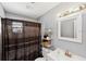 Cozy bathroom offers shower with curtain, white vanity, and updated lighting at 2822 Fulford St, Deltona, FL 32738