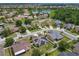 An aerial view of a real estate neighborhood with a lake and houses with orange and grey roofs at 2860 Orange Haven Way, Kissimmee, FL 34746