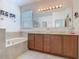 Bright bathroom featuring double vanity with granite countertops and separate tub at 2860 Orange Haven Way, Kissimmee, FL 34746